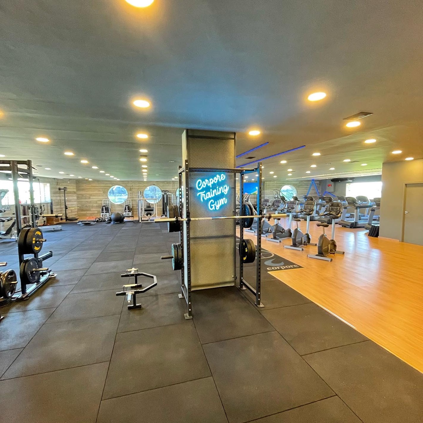 Área Corpore Training Gym com racks e equipamentos cardiovasculares